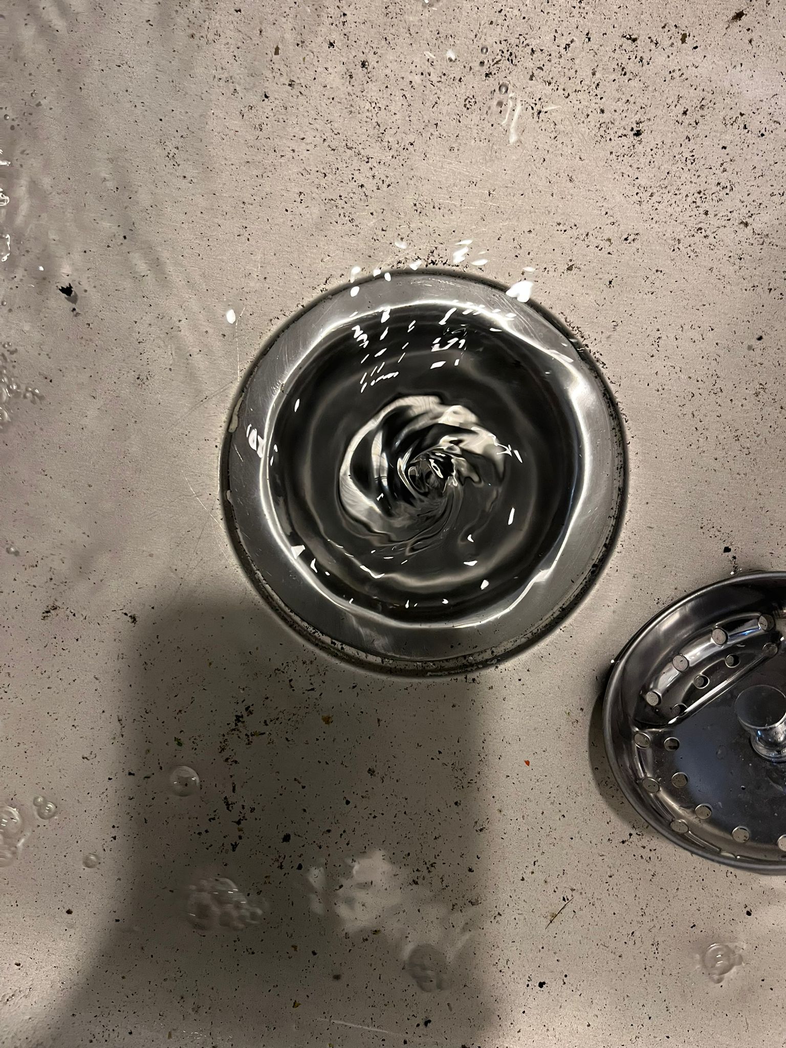 Cleared drain opening with swirling water after blockage removal, drain cleaning in Maple Ridge