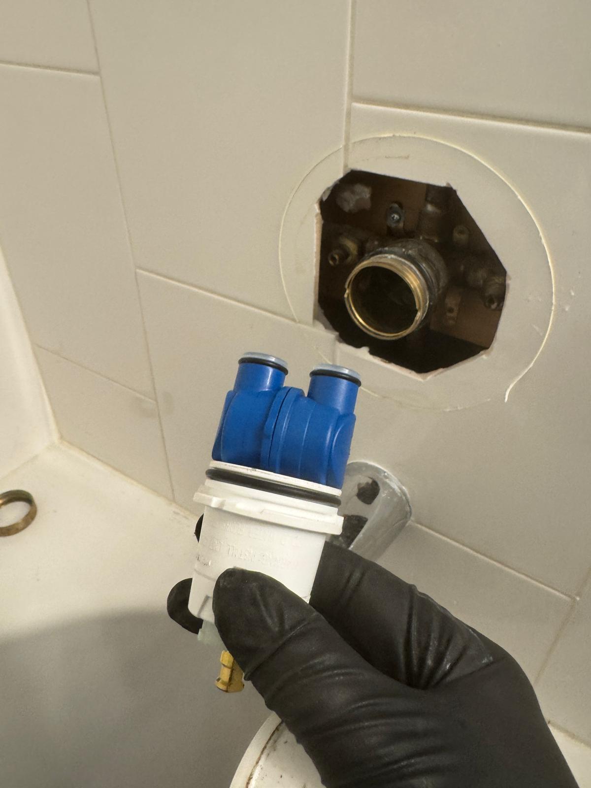Carefully removing damaged shower handle during emergency plumbing repair in Port Moody