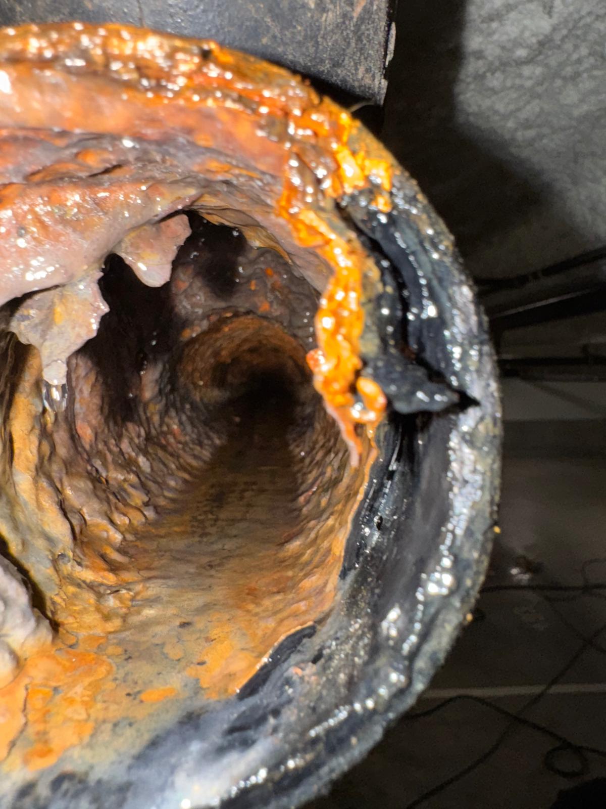 Heavy grease and debris buildup inside parkade drain before cleaning, commercial plumbing in Richmond