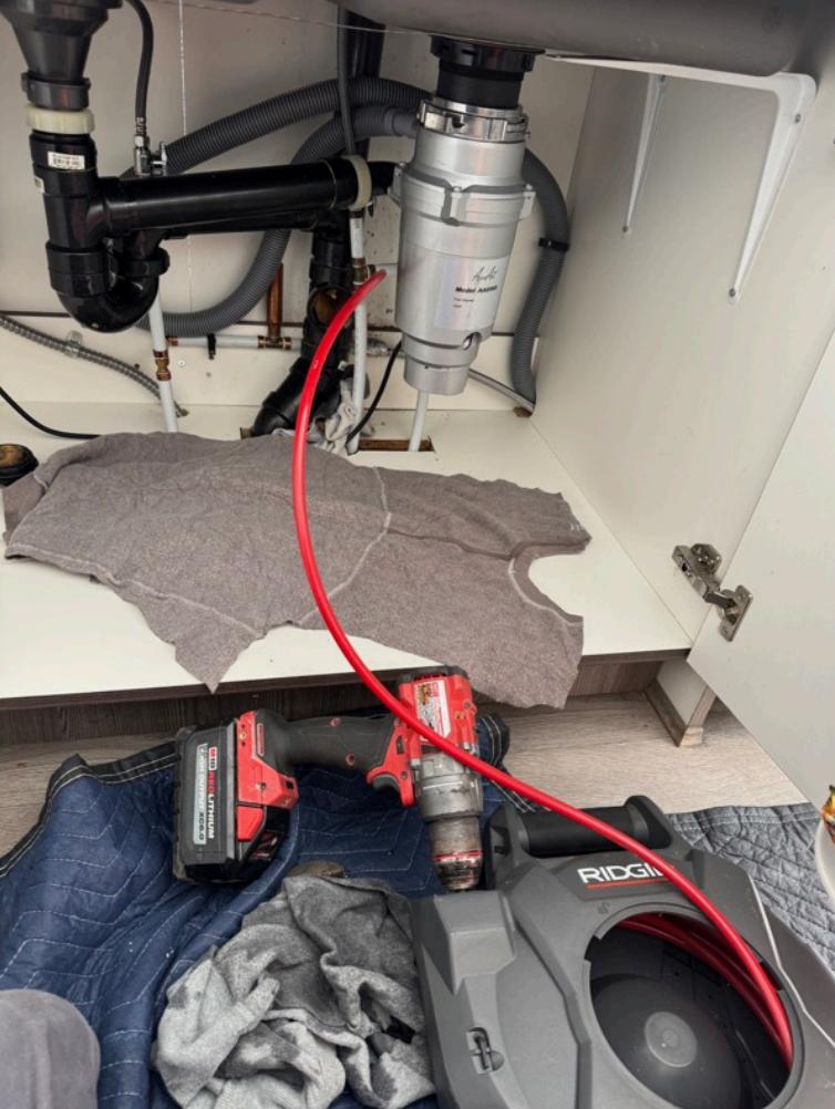 ridgid drain snake and milwaukee drill under sink - garbage disposal plumbing