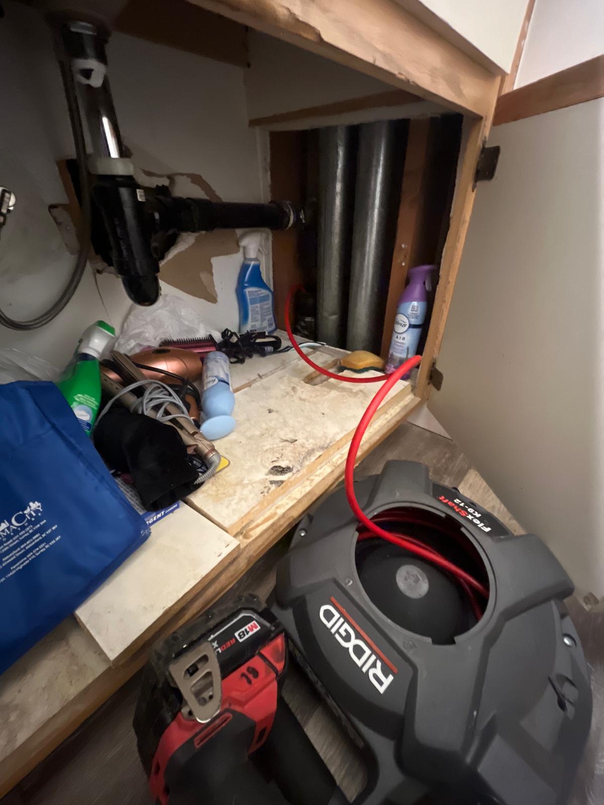 Feeding drain snake into sewer line during commercial plumbing work in Abbotsford