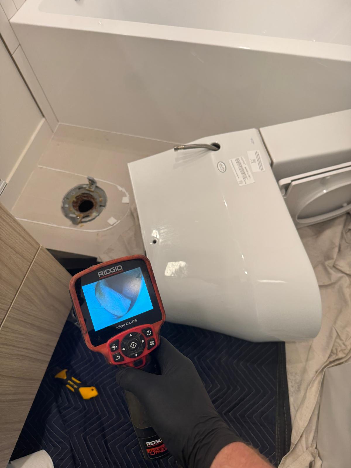 Toilet removed and flange exposed while technician uses drain camera, drain cleaning in Coquitlam
